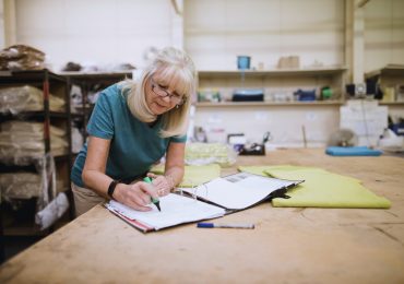 Senior,Businesswoman,Is,Doing,Paperwork,In,Her,Stock,Factory.