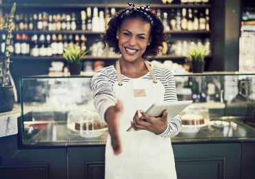Smiling,Young,African,Cafe,Owner,Extending,A,Handshake,While,Standing